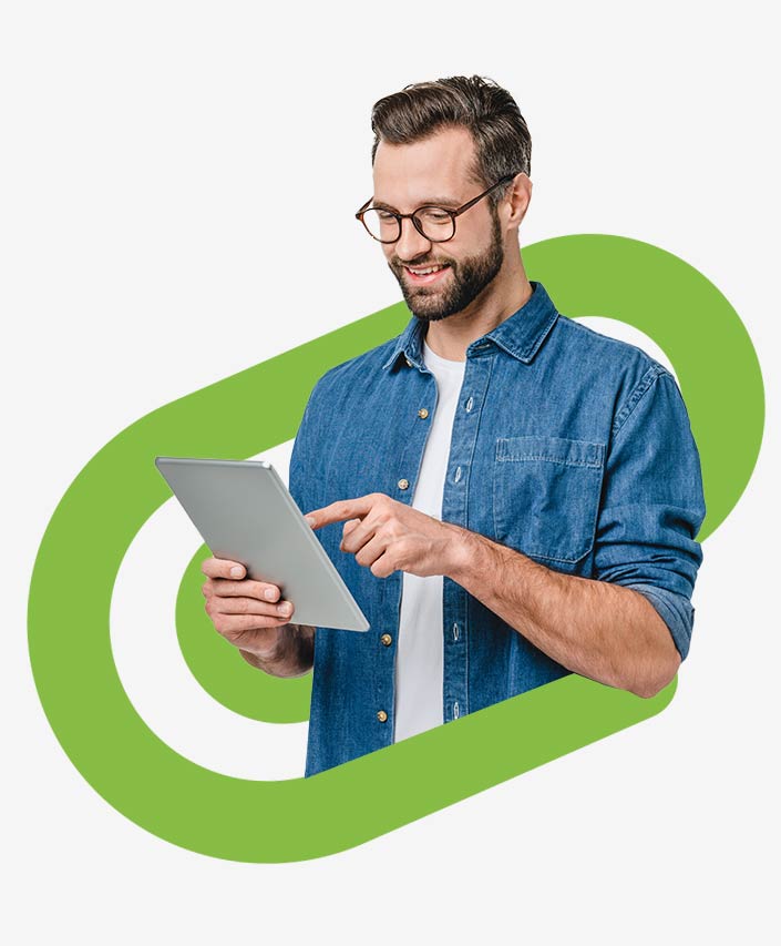 Ein Mann mit Brille und Jeanshemd arbeitet auf einem Tablet - und verwaltet Medien in Dynamics CRM ganz einfach mit awisto AttachPLUS