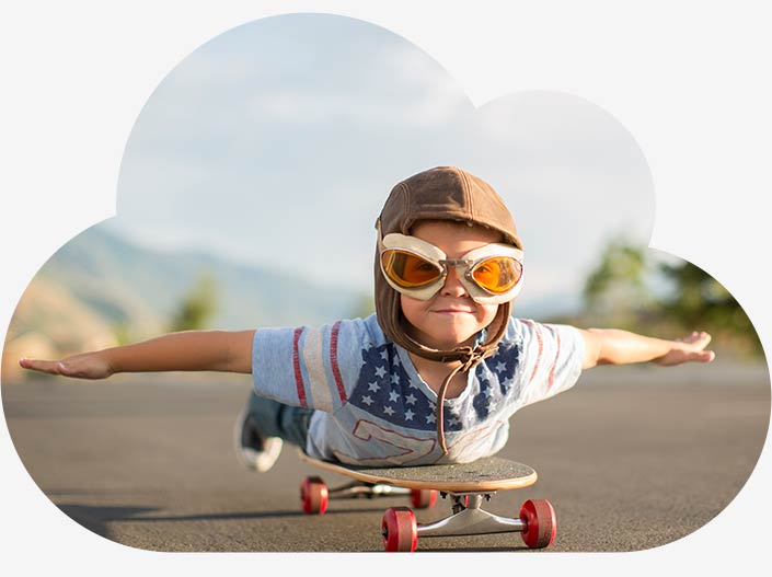 Ein Junge mit Fliegerbrille liegt bäuchlings auf seinem Skateboard und hat die Arme seitlich ausgestreckt. Als würde er fliegen. Er symbolisiert unsere Vision für die Digitalisierung.